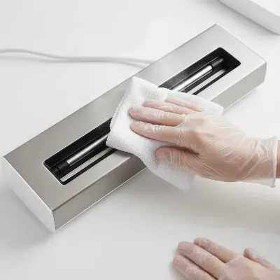 Person wiping a vacuum sealer heat bar with a white cloth.